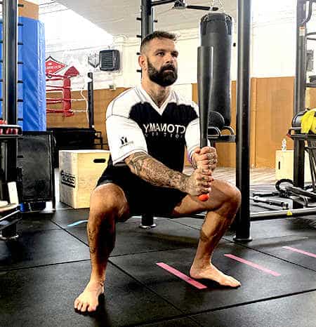 Un uomo che si allena con una mazza da baseball in palestra.