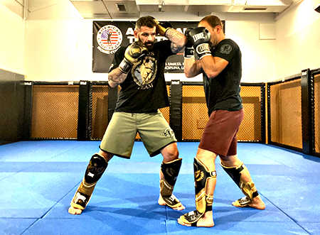 Due uomini che praticano Corso di Thai-Kick boxe in una palestra.
