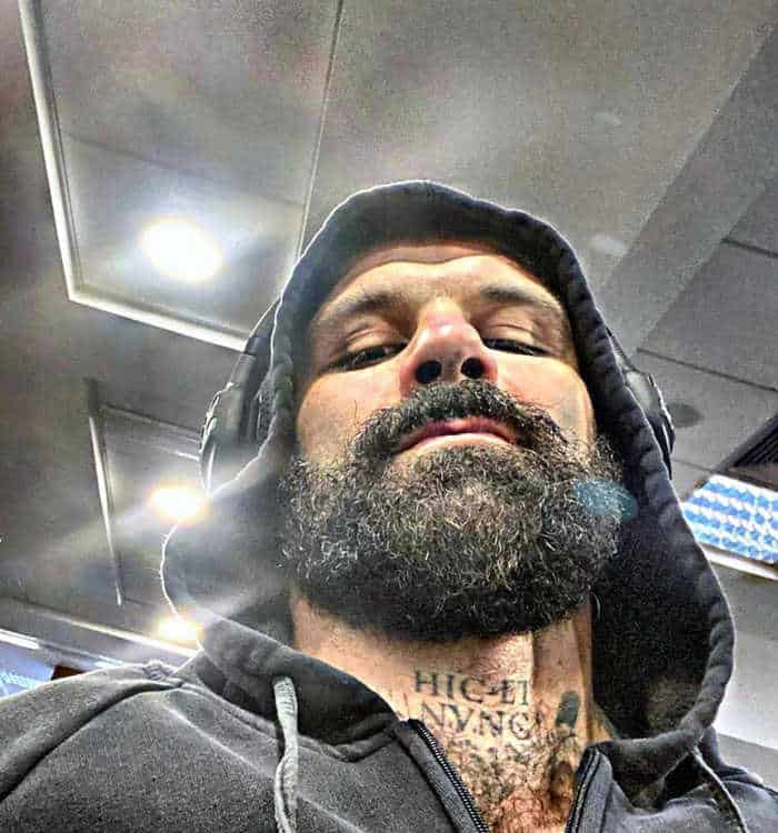 Un uomo con una cotta da mostro metabolico e tatuaggi.